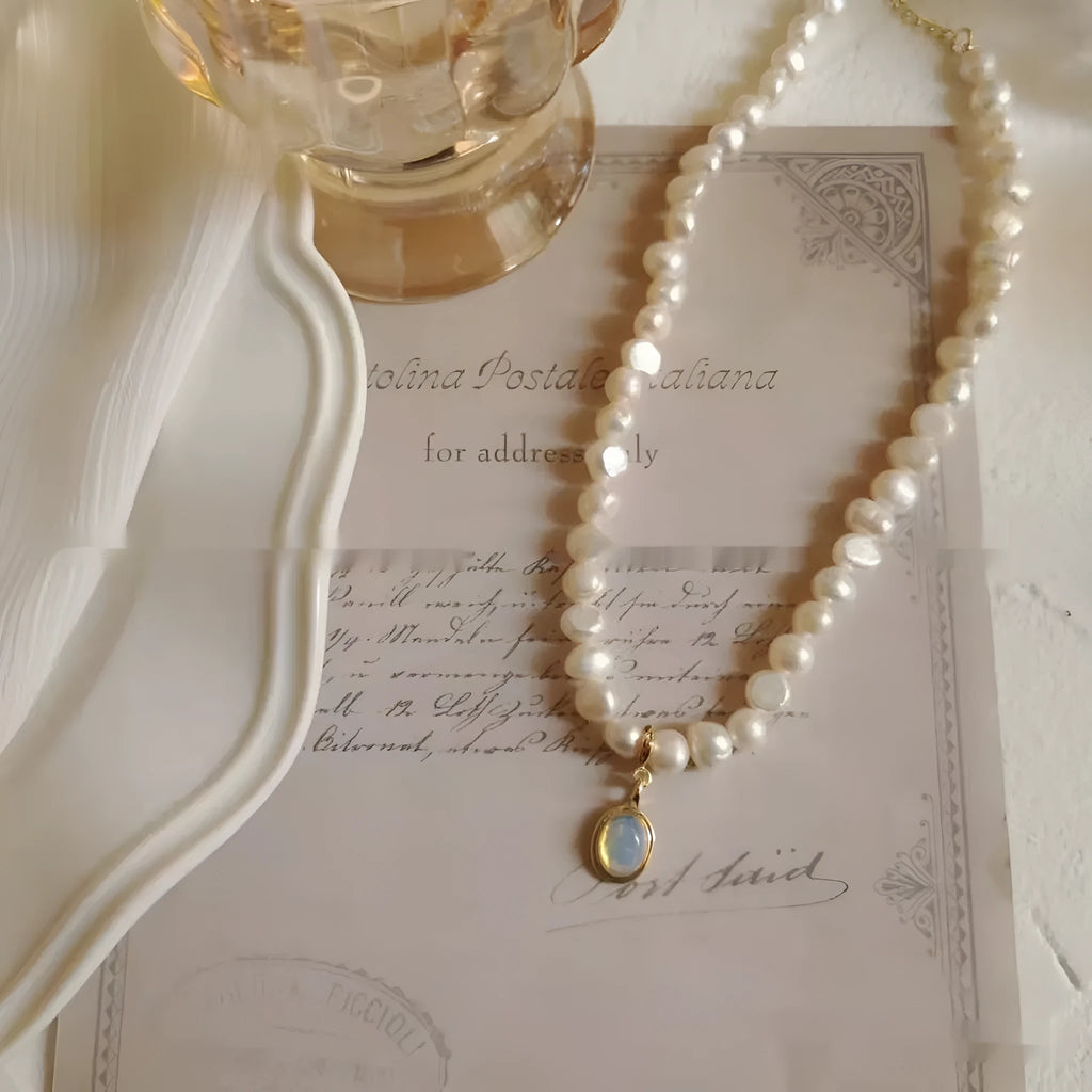 Vintage geometric pearl necklace with an adjustable chain from 21cm to 50cm on a grey background.