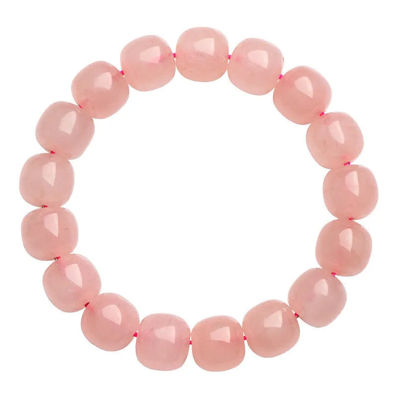 Pink natural crystal barrel bead bracelet with geometric beads on an elastic cord.