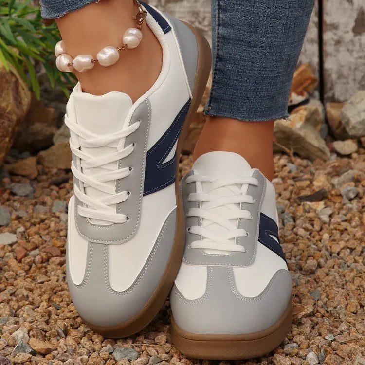 Blue women's low-top hiking shoes with rubber sole and lace-up design on an outdoor background.