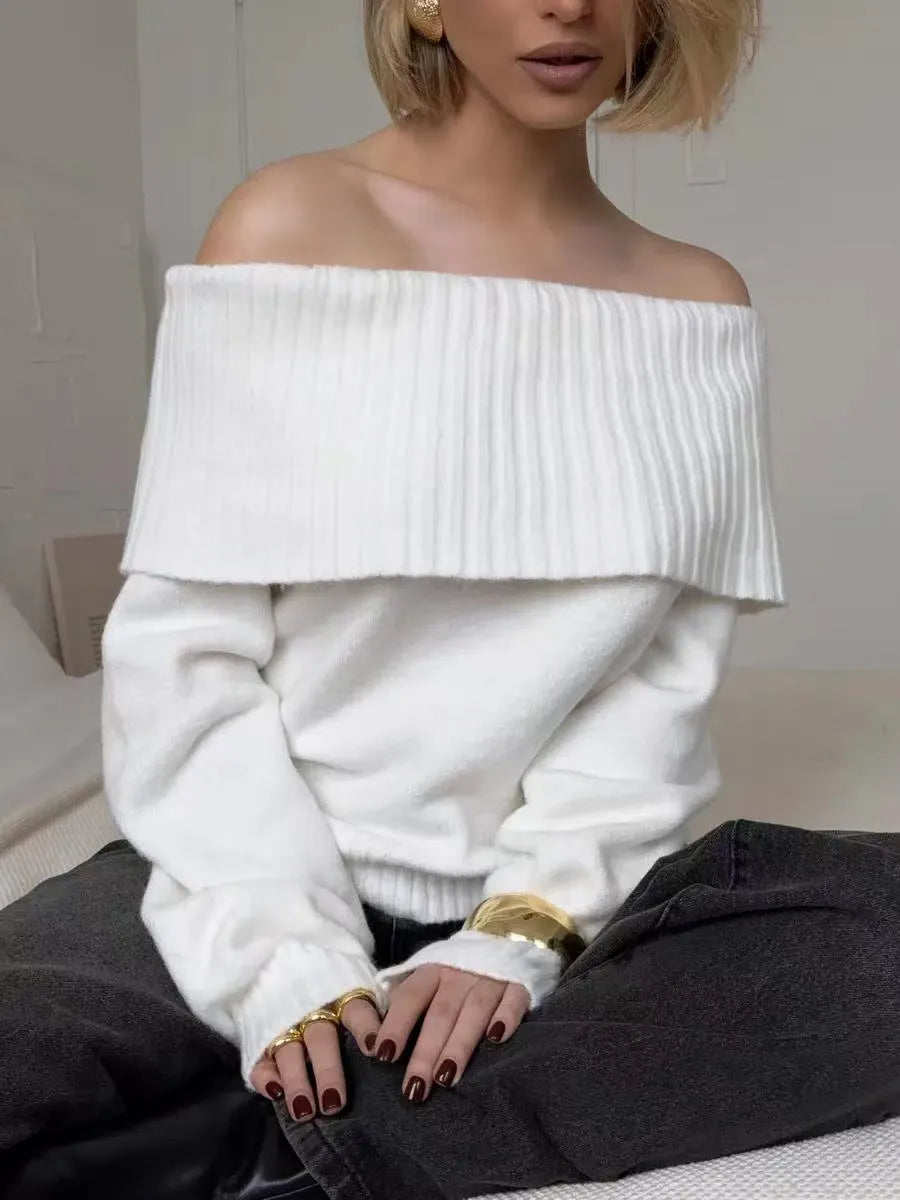 Grey off-the-shoulder acrylic sweater with a textured 3D pattern on a hanger.