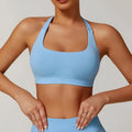 Women's black halter sports bra with hollow back and removable padding for yoga and workouts.