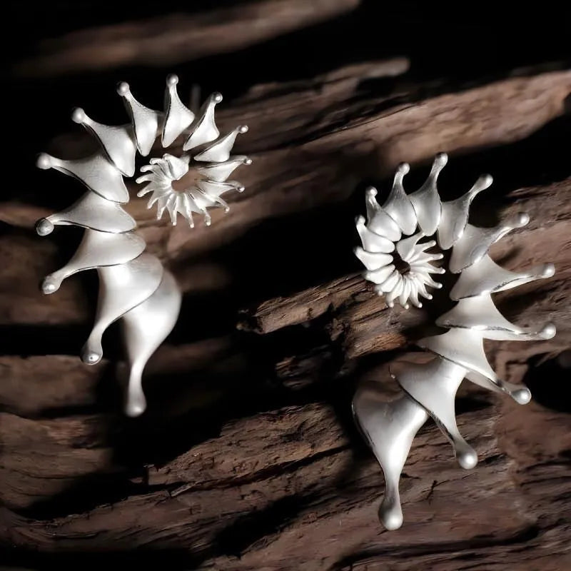 A pair of matte finish conch stud earrings with a three-dimensional, irregular alloy design.