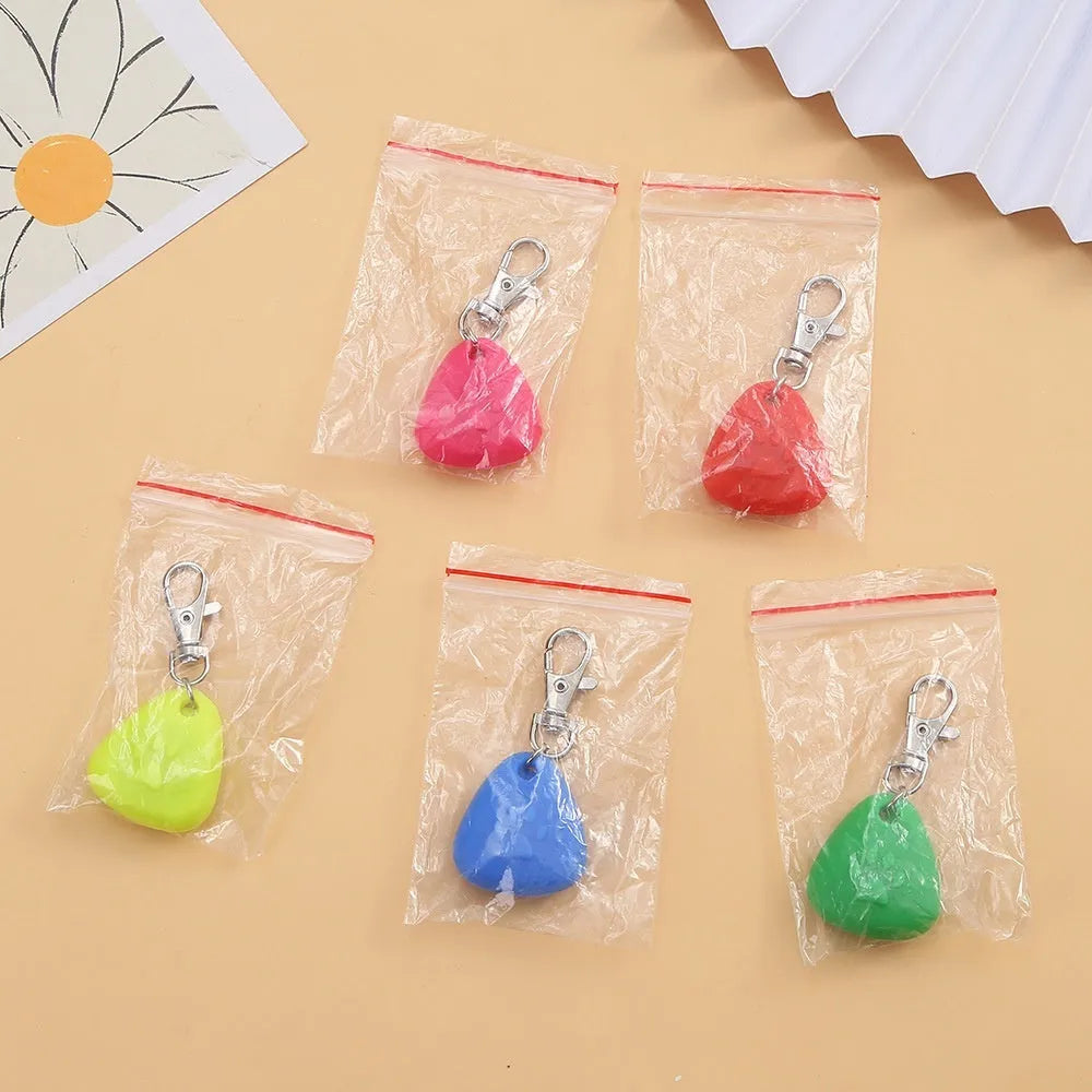 A glowing triangular silicone pendant ornament for pets, shown in various colours on card packaging.