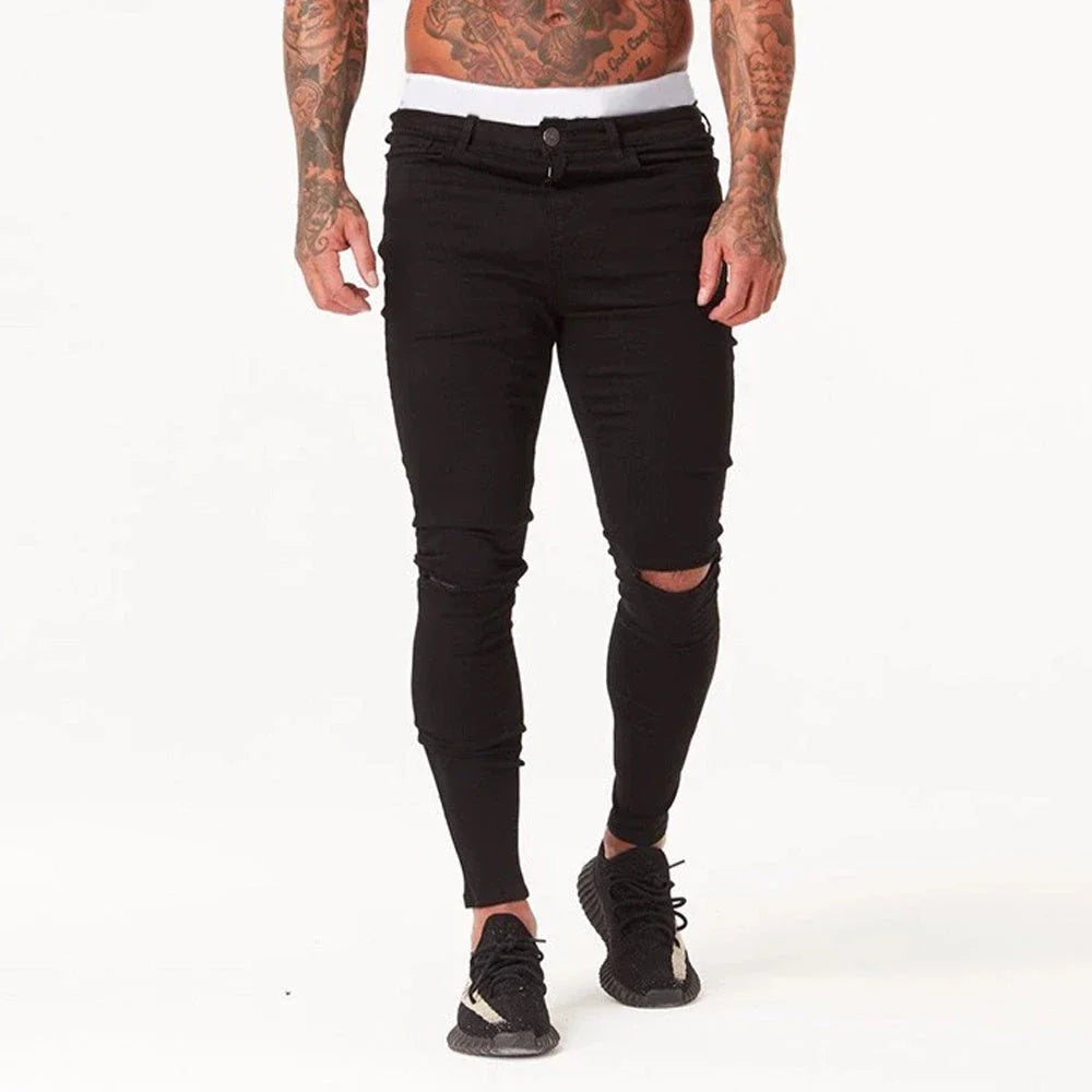 Premium distressed men's slim-fit jeans in black, featuring a stretchy mid-rise design and edgy, on-trend detailing