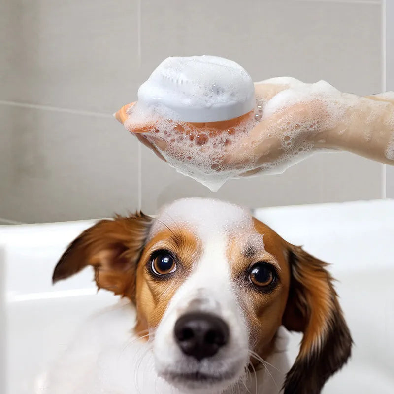 Orange dog bath brush with shampoo dispenser and soft TPR bristles for pet grooming