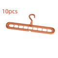 A green nine-hole plastic folding hanger for organising trousers and saving wardrobe space.