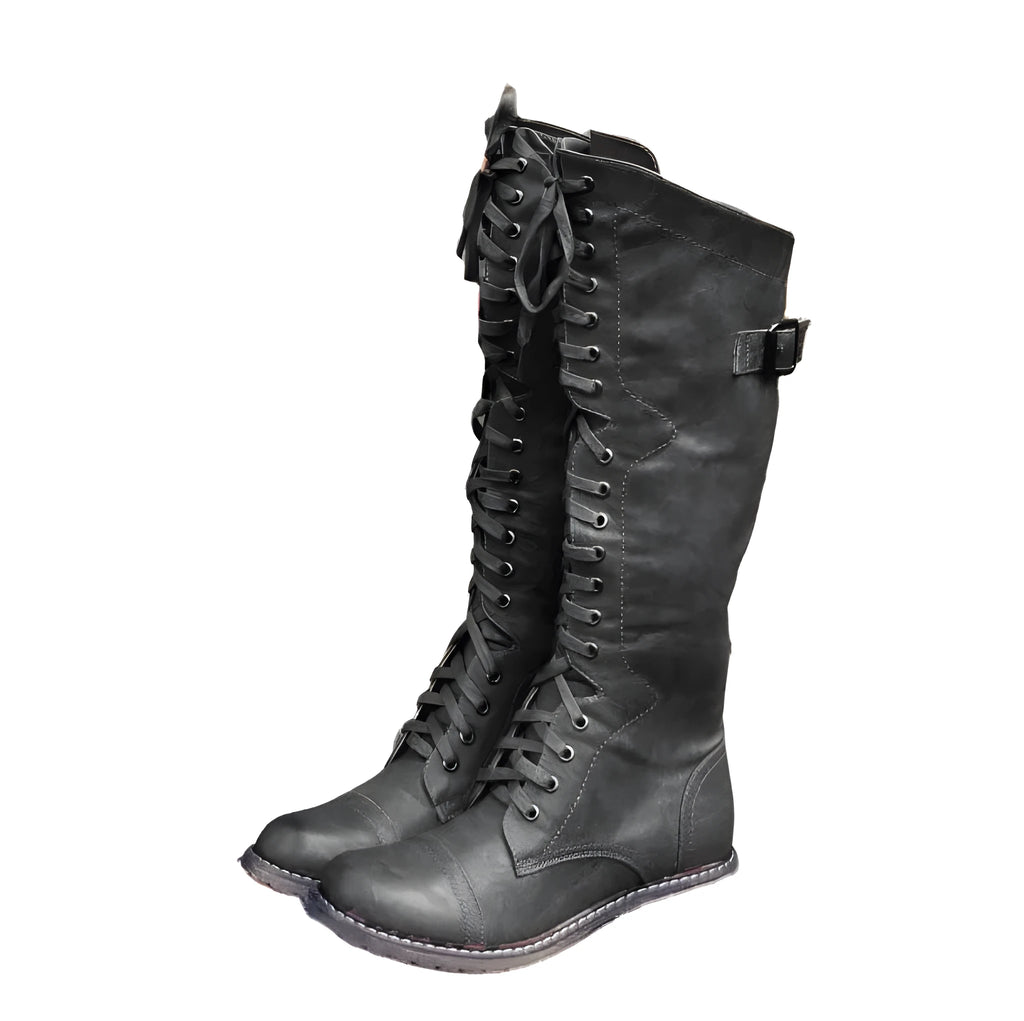 Women's black knee-high knight boots with a cross strap detail across the ankle.