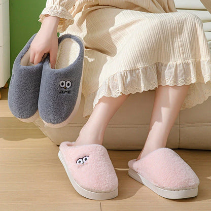 Cozy cartoon slippers with big eyes in various colors, featuring plush material and non-slip rubber soles for comfortable indoor wear