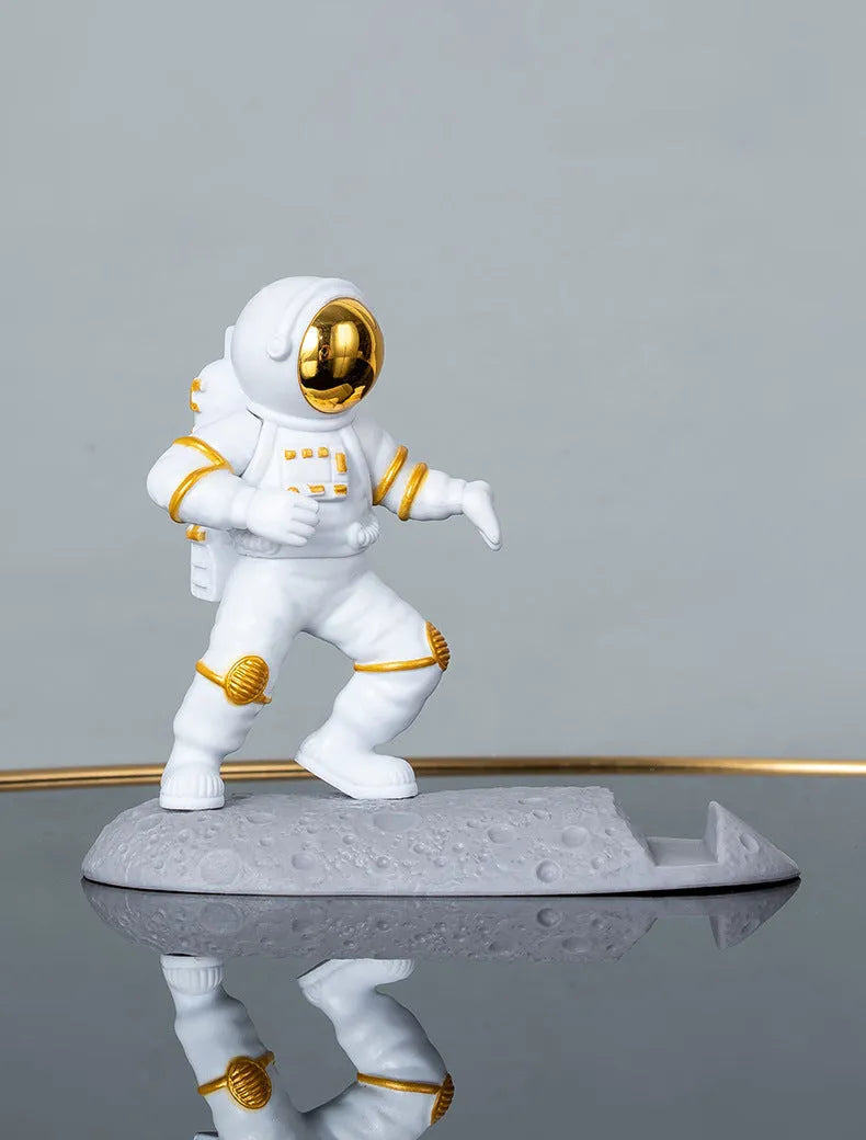 Plastic astronaut decoration mobile phone holder in blue colour on a desk