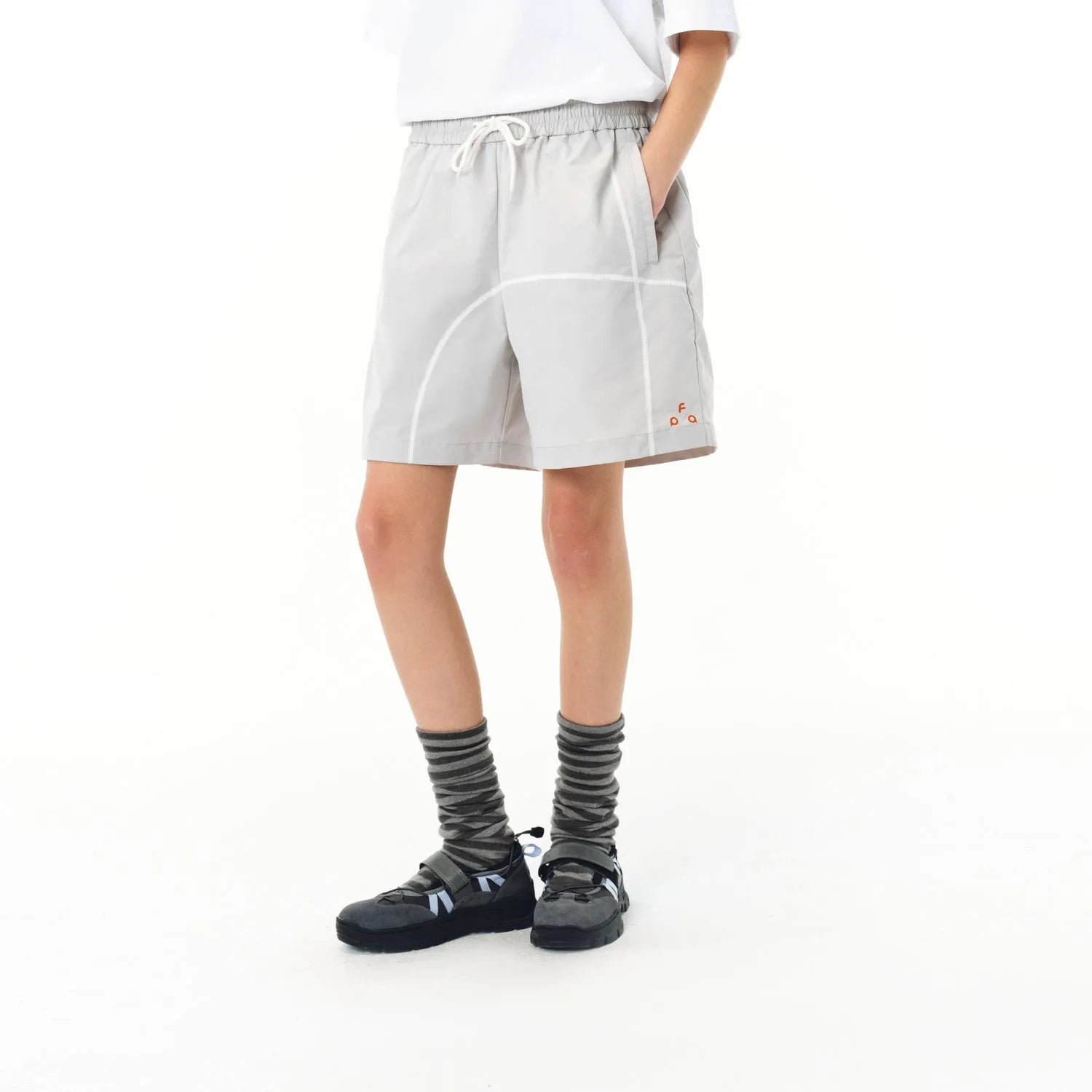 Man wearing retro grey drawstring beach shorts made from high elasticity polyester fabric.