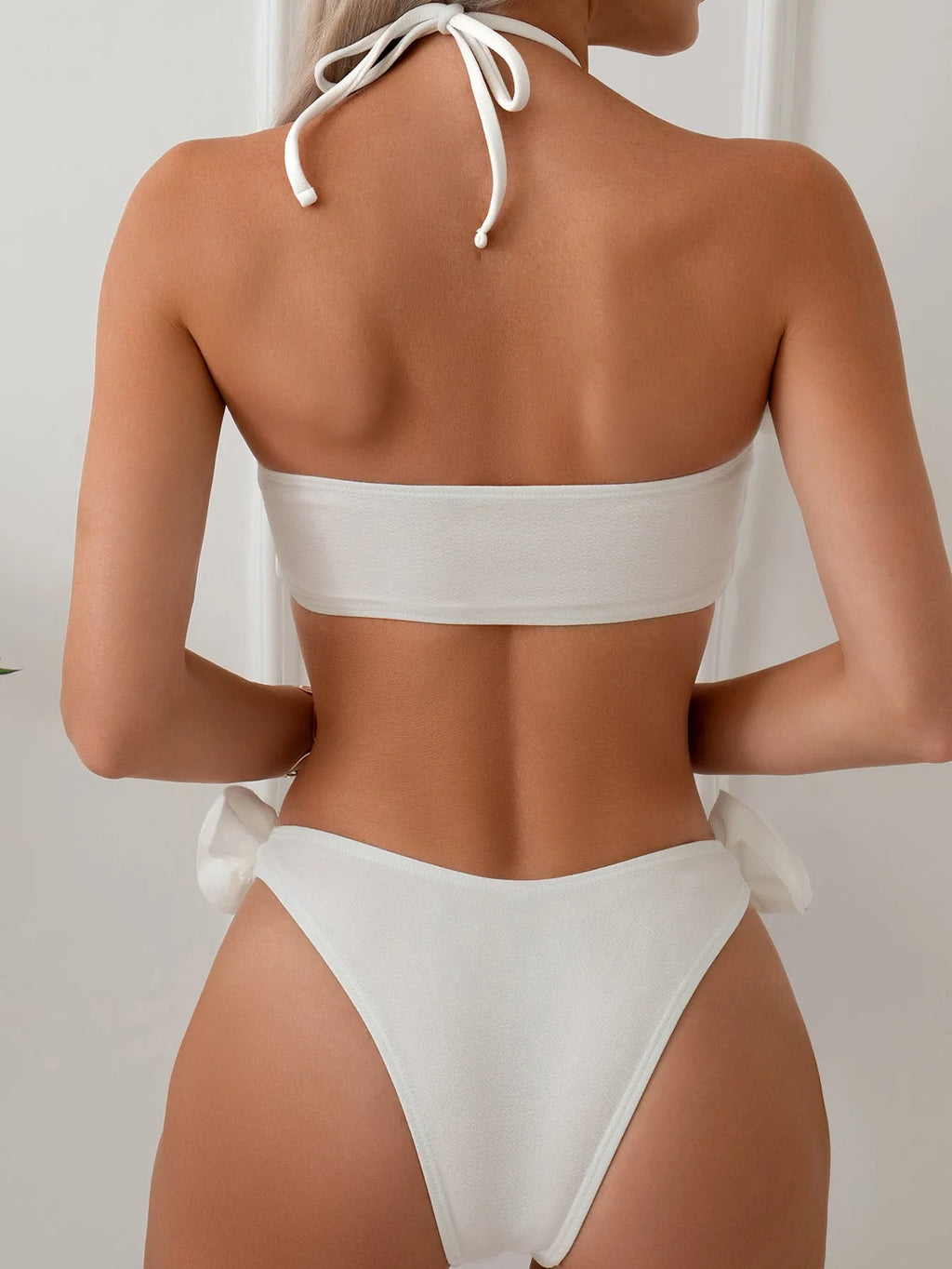 White halter neck bikini set with 3D flower design and lace-up back