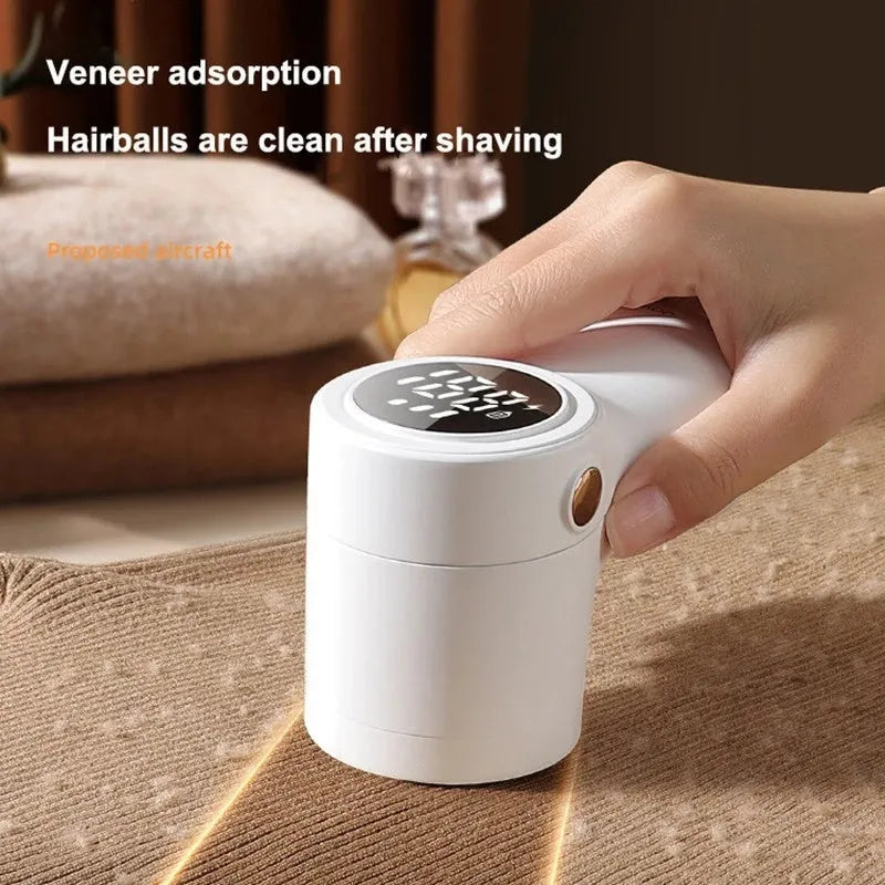 White electric lint remover with LED display and USB port on a fabric background.