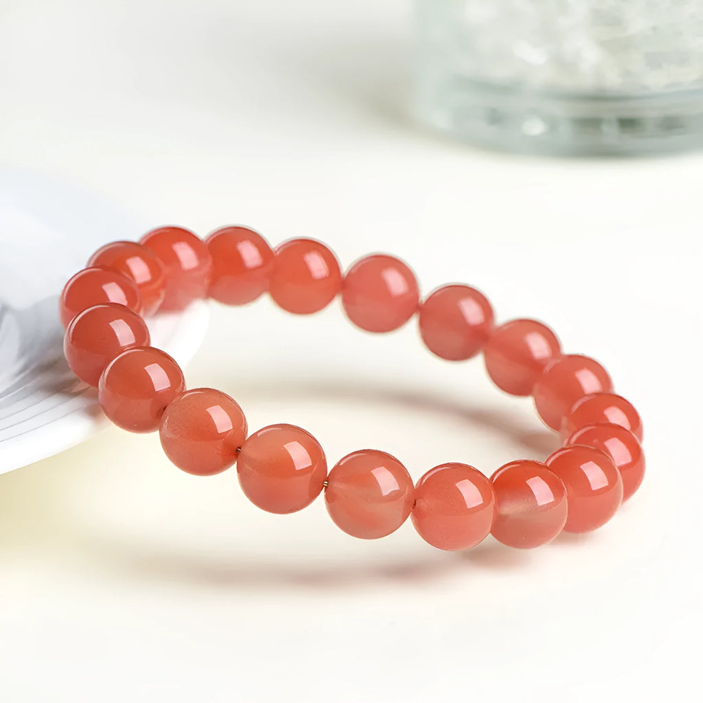 Natural South Red Cherry Agate bracelet on a wrist, showing polished beads in a single strand design.