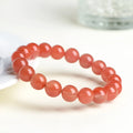 Natural South Red Cherry Agate bracelet on a wrist, showing polished beads in a single strand design.