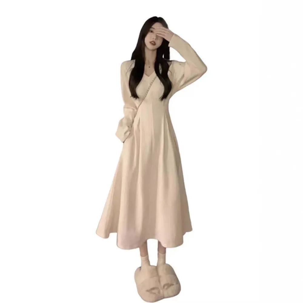 Women's milky white V-neck knitted long dress with princess sleeves on a hanger.