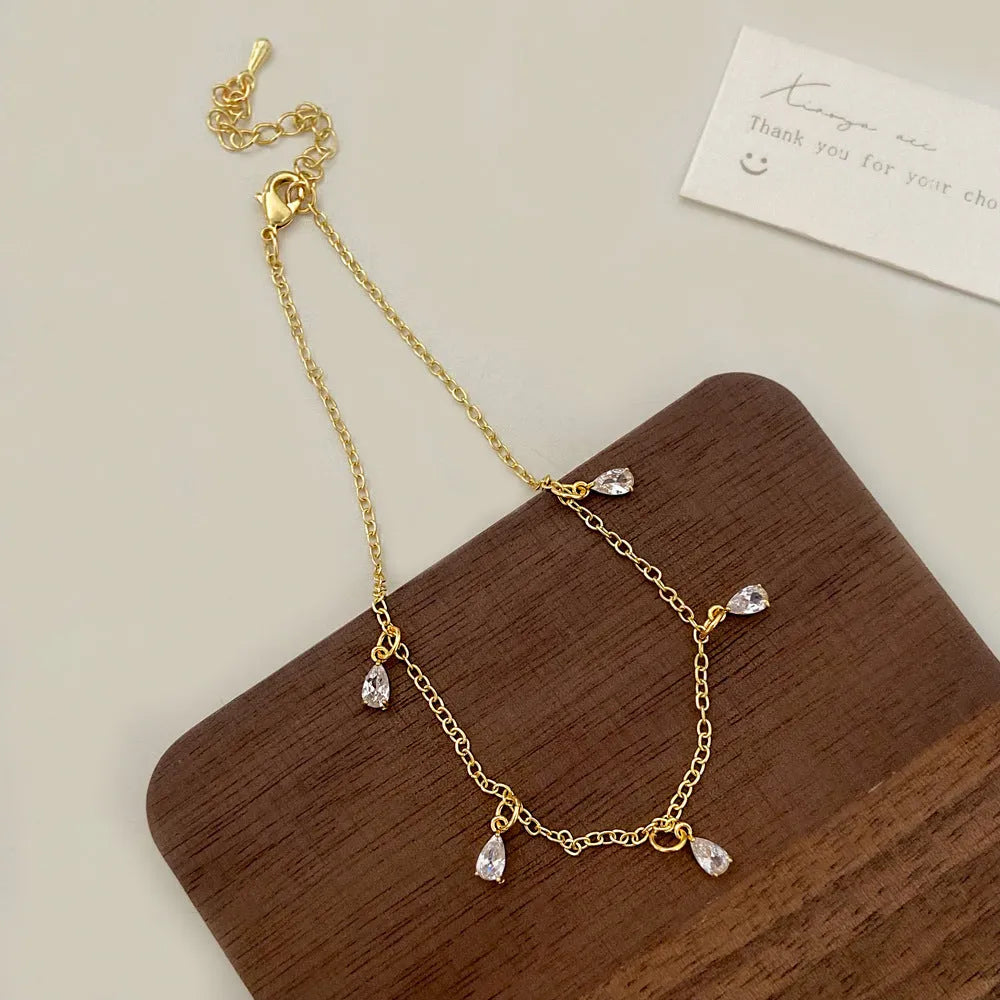 Women's zircon necklace, earrings, and anklet set with geometric meteor shower design.
