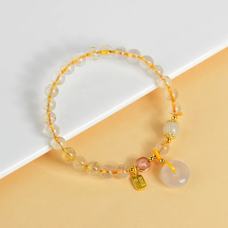 Gold rutilated quartz crystal bracelet with peace buckle closure and blessing card pendant