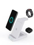 Black 3-in-1 wireless charging stand holding a phone, an Apple Watch, and AirPods case on a desk.