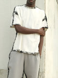 White casual short sleeve top with draped neckline and printed design detail.