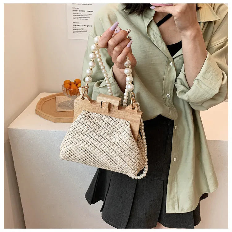 Women's woven straw shoulder bag with pearl chain detail, shown in beige, featuring internal organiser pockets.