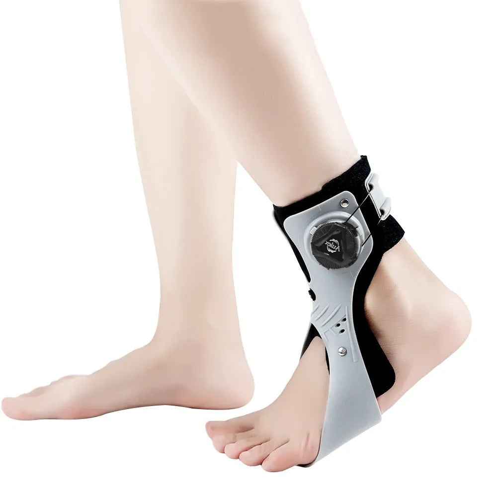 Adjustable ankle fixation brace with airbag button in black or grey colour, shown on a foot.