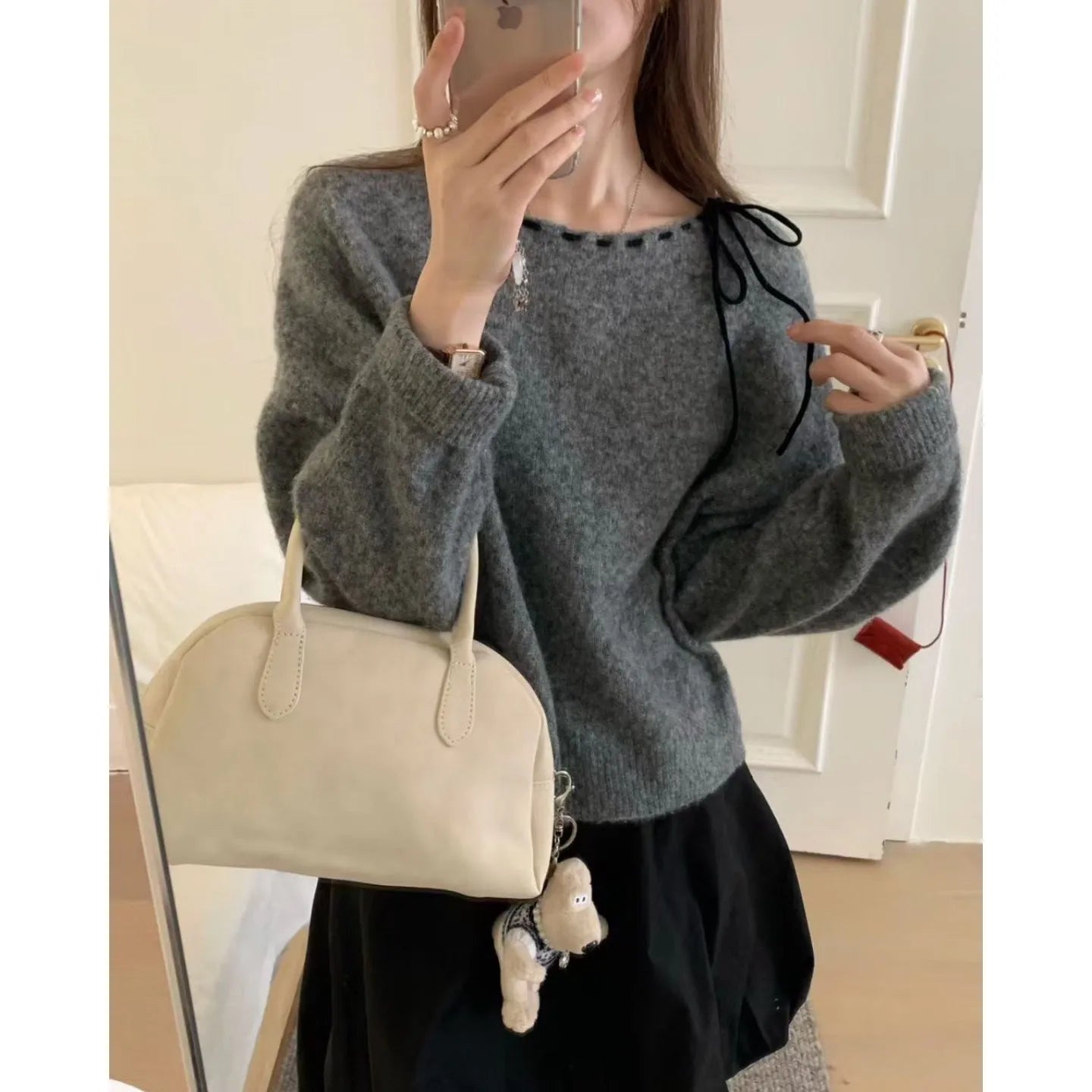 Grey loose-fitting women's knitwear pullover on a hanger.