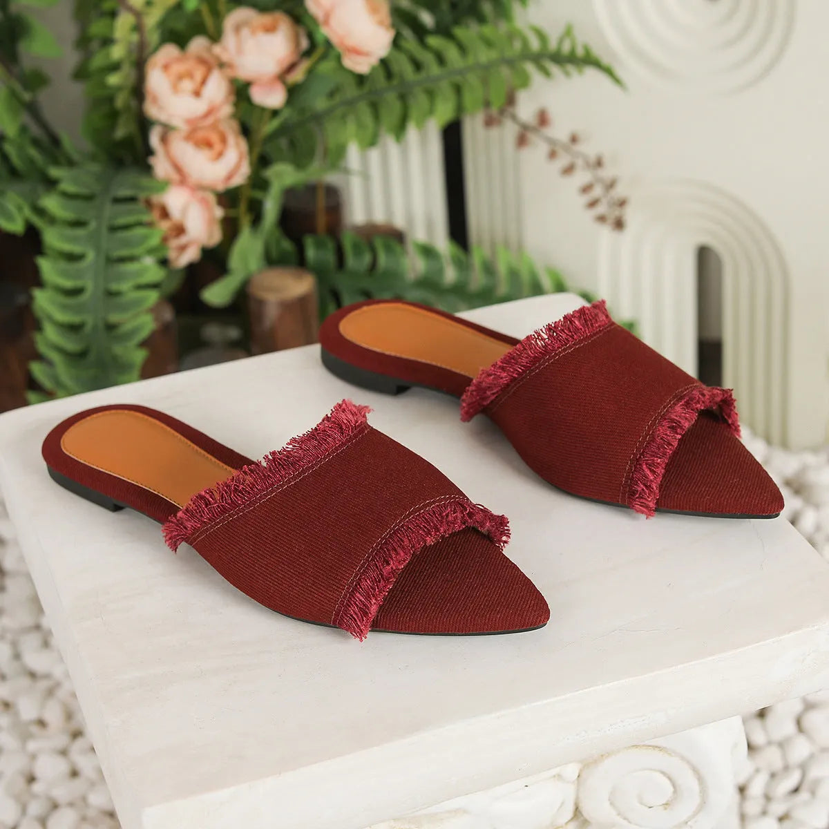 Women's flat denim slippers with a tassel decoration in apricot colour.