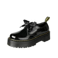 Black thick-soled women's leather shoes with cross-strap ribbons and lace-up closure on a white background.
