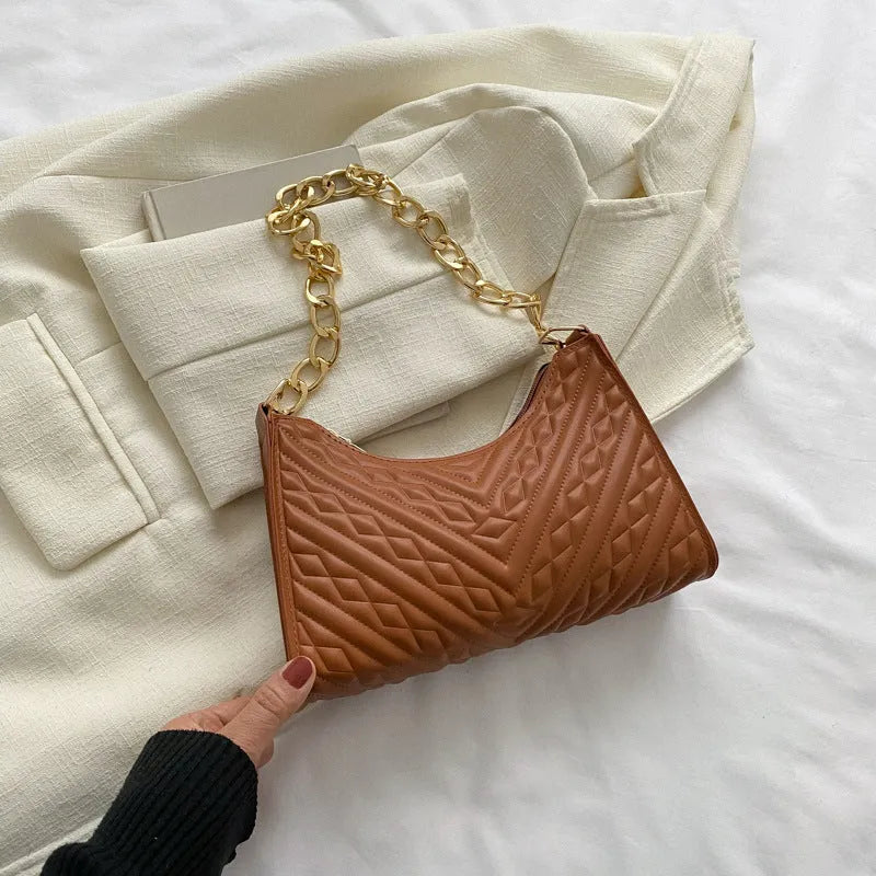 Brown pleated chain strap baguette shoulder bag showing vertical square shape and soft handle.