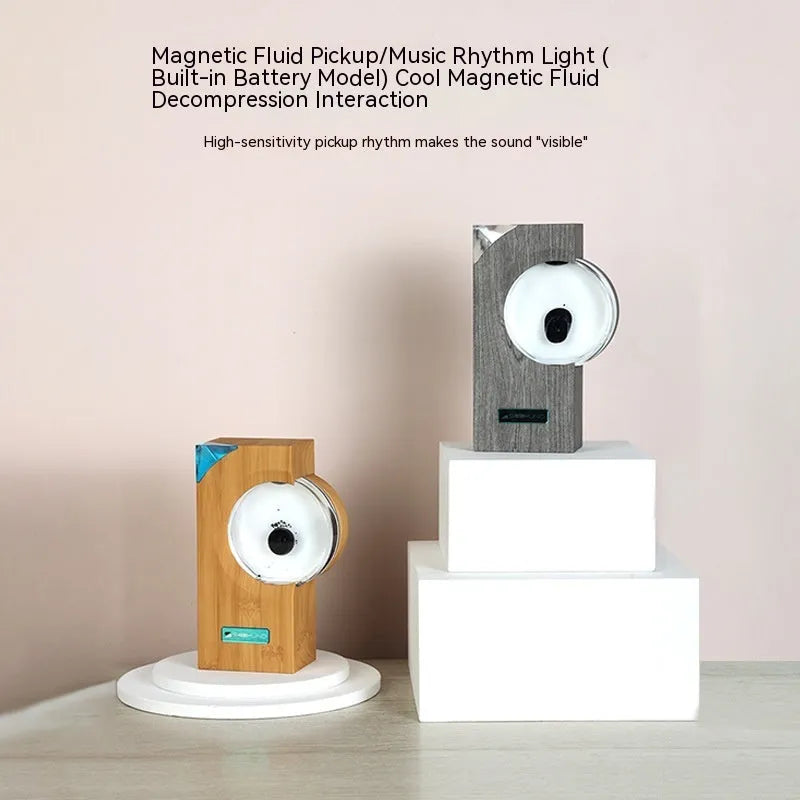 Ferrofluid speaker with magnetic fluid dancing in yellow plastic housing on desk