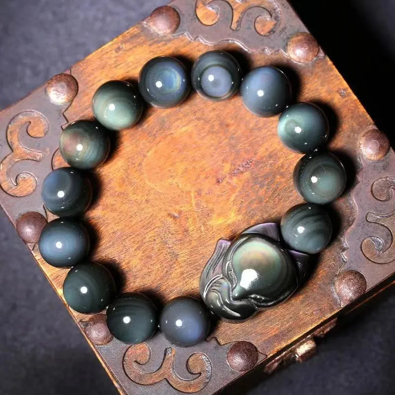Black obsidian stone bracelet with carved fox design in cartoon style, showing texture and adjustable sizing