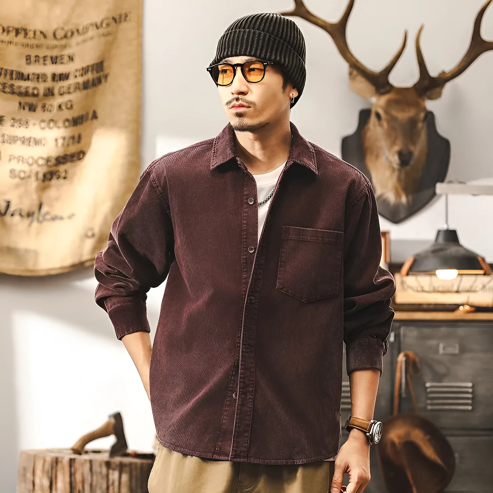Men's red corduroy loose-fit shirt jacket with long sleeves on a hanger.