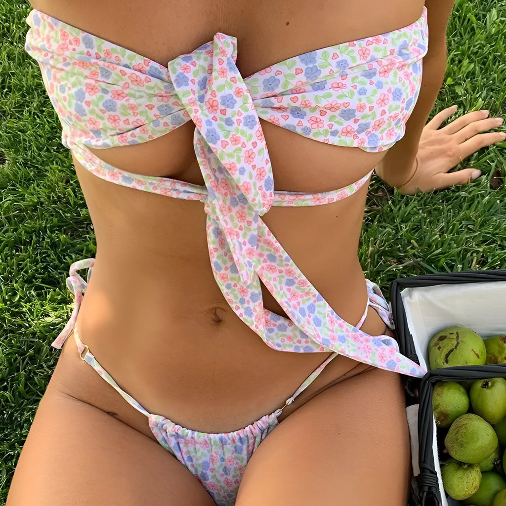 A woman's wire-free one-piece swimsuit with padded cups and lace-up sides, shown in a floral print.