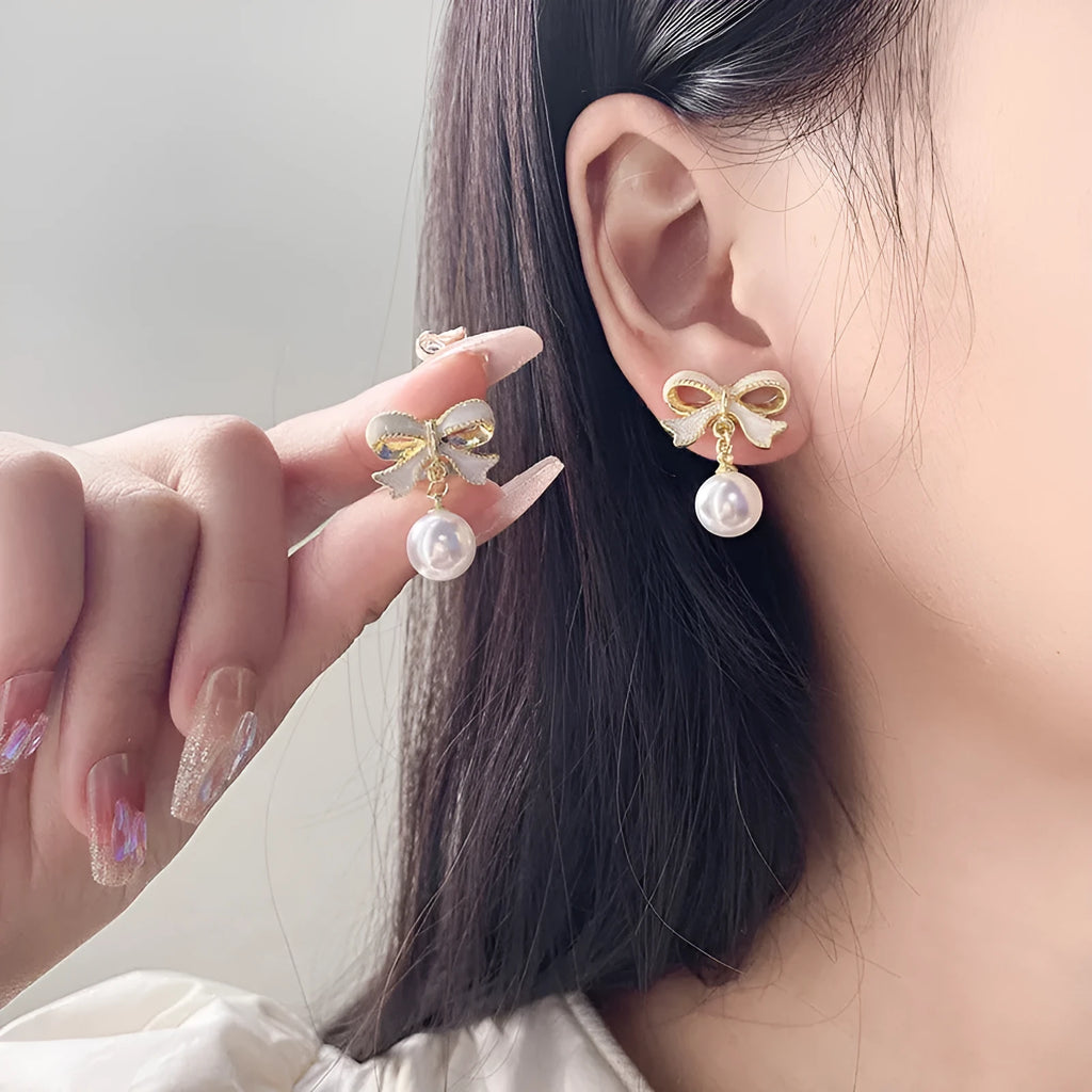Alloy bow shape drop oil ear studs with electroplating finish in aurora white colour