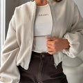 Women's milky white off-shoulder jacket with long lantern sleeves and pockets.