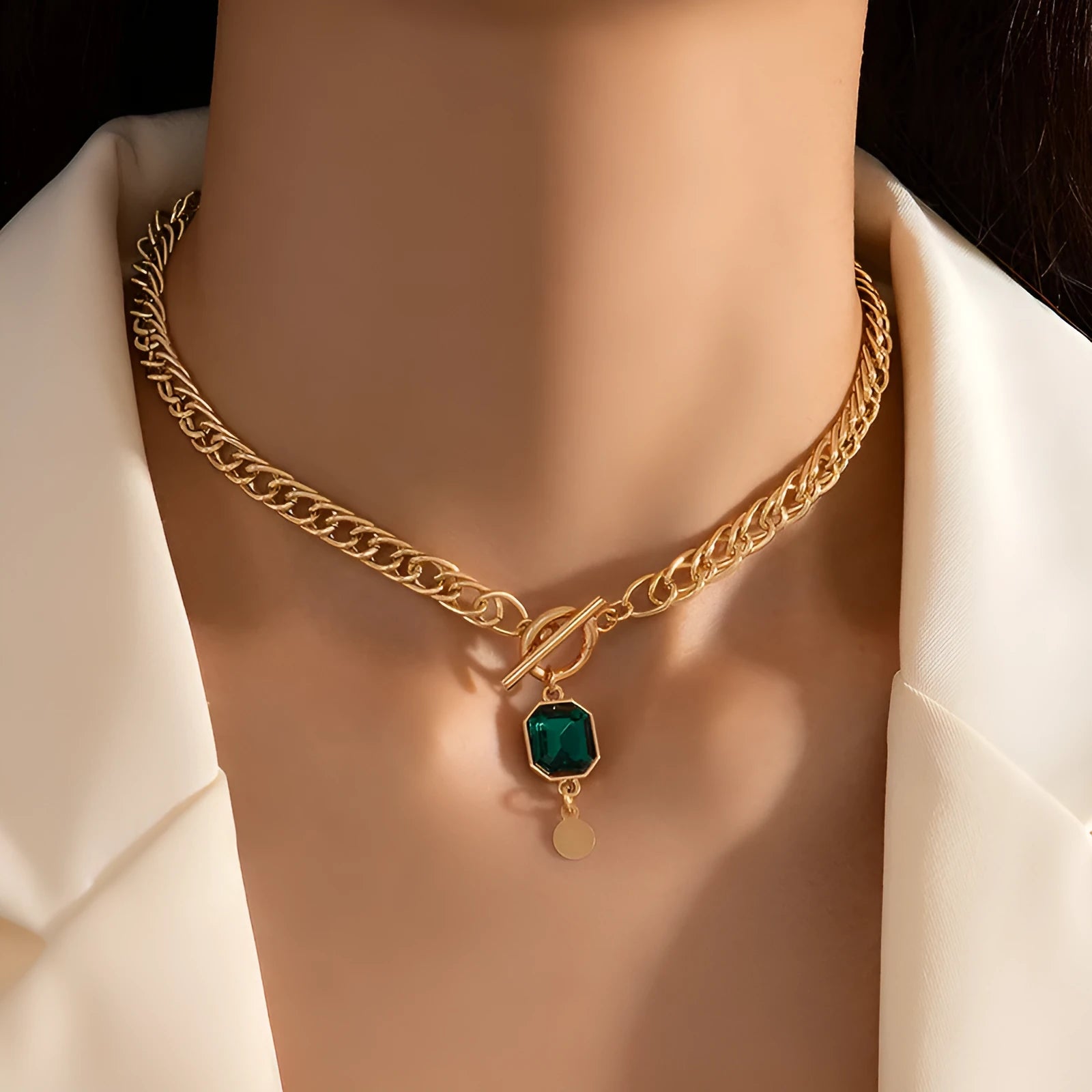 Gold titanium steel necklace with geometric pendant containing emerald zircon stone