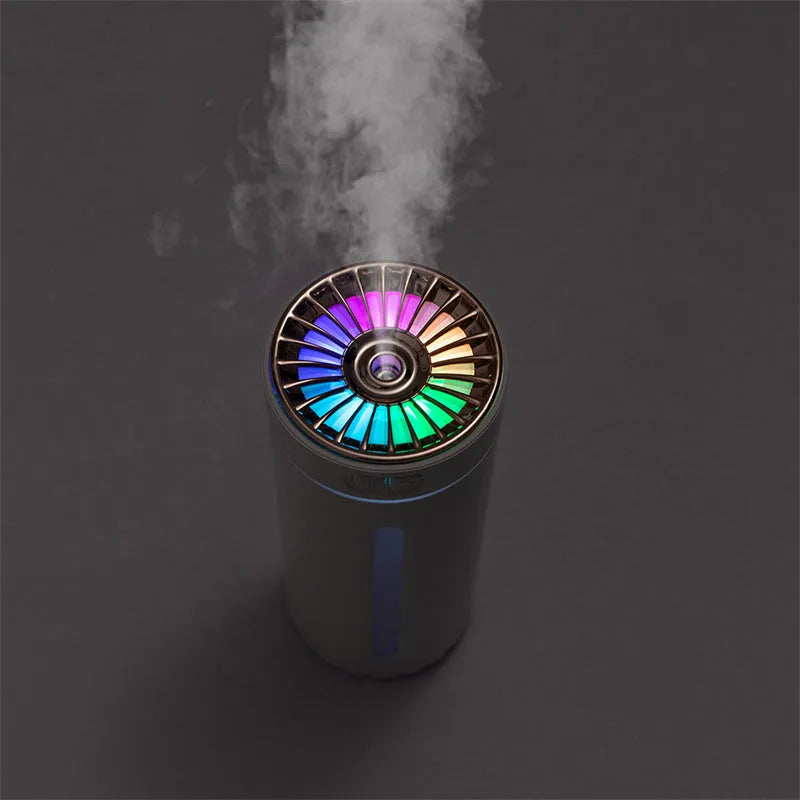 Compact black wireless USB humidifier with colourful LED lights on a car cup holder.