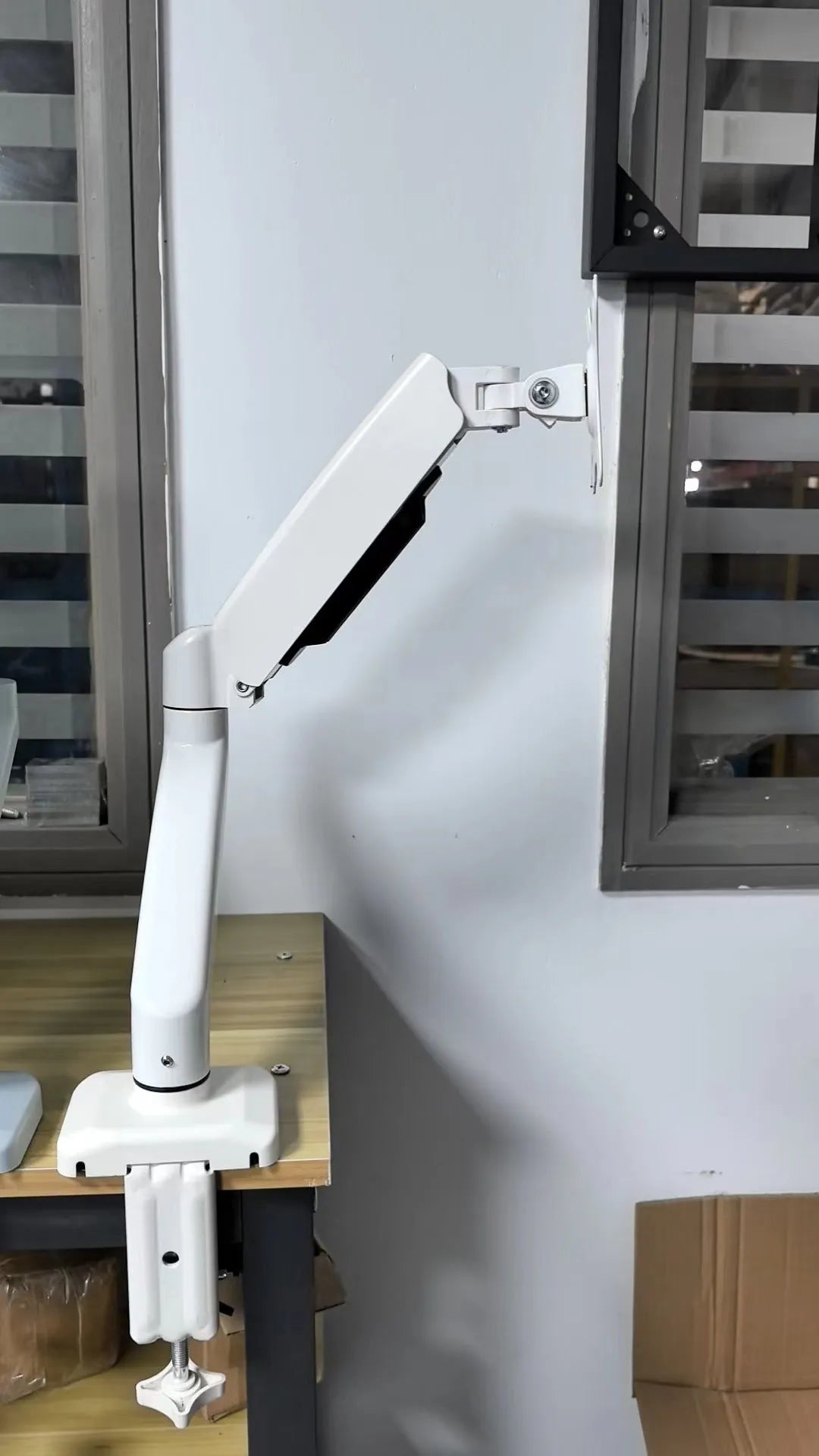 Black table-top rotating telescopic bracket holding an LCD computer monitor