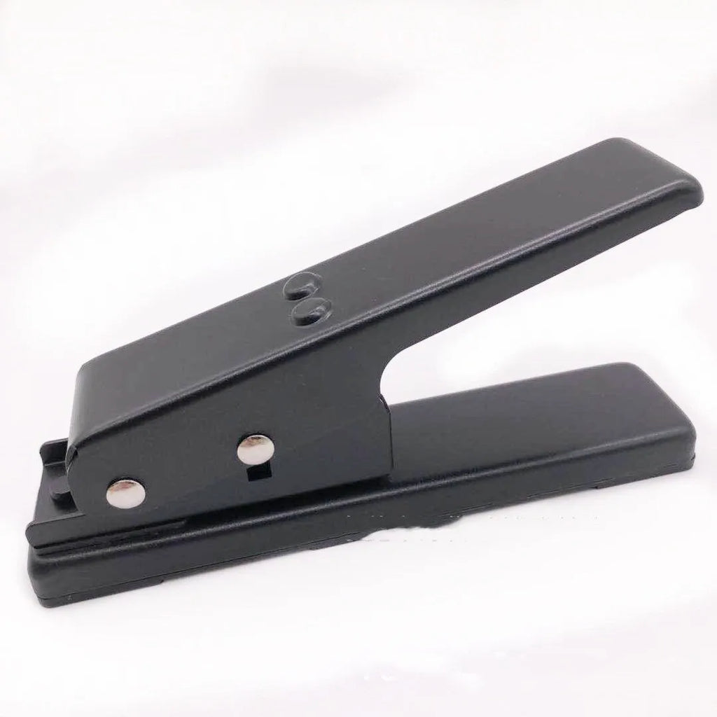 Gold metal guitar pick card cutter on a dark surface with a cut plastic plectrum nearby