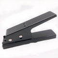 Gold metal guitar pick card cutter on a dark surface with a cut plastic plectrum nearby