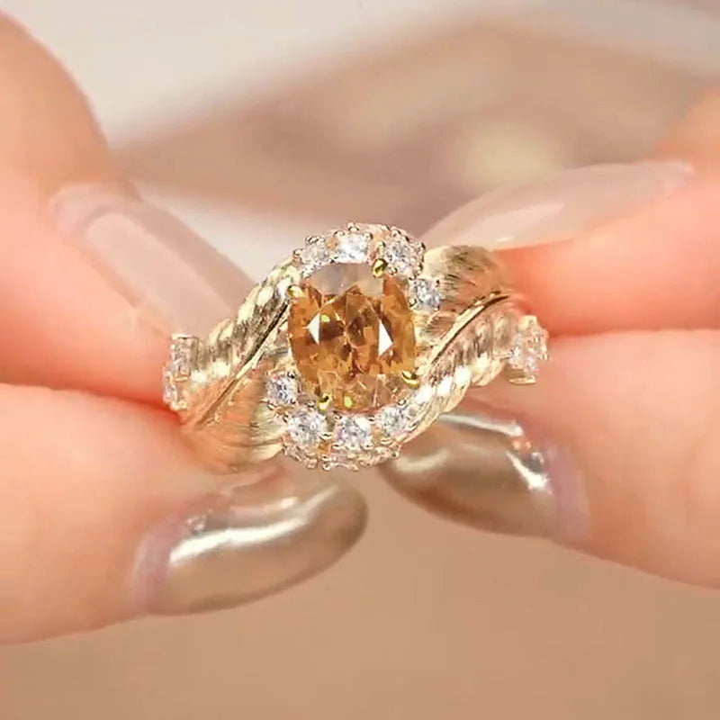 Gold women's ring with embossed feather design and yellow zircon stones on geometric shape