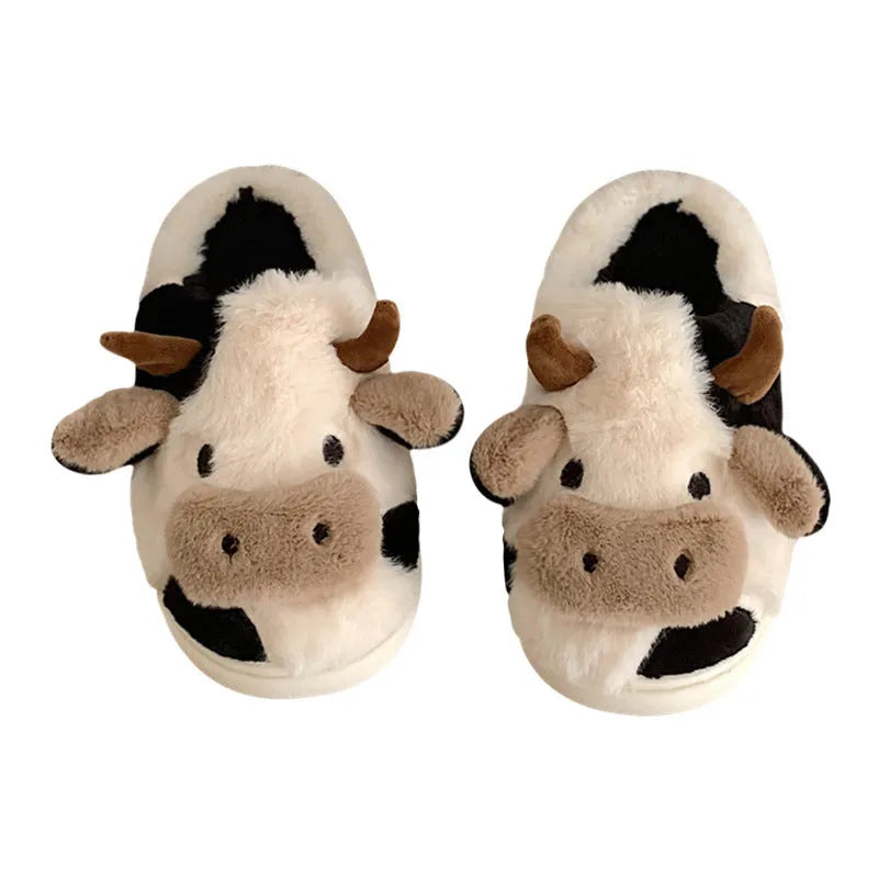 White cow-themed faux fur slippers with black spots and a textured grey anti-slip sole.