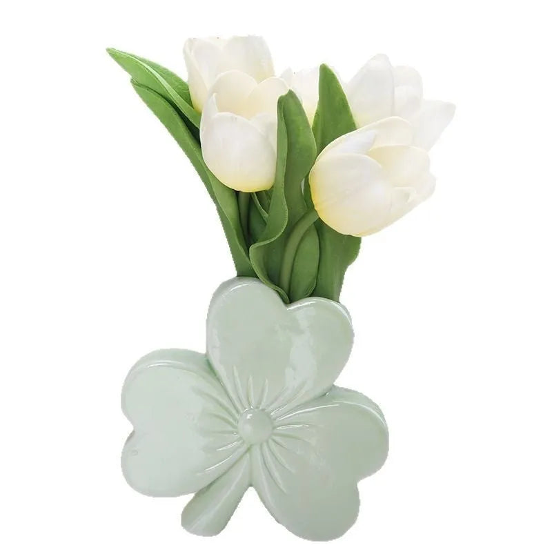 Small clover-design ceramic vase in pink, red, light green, or white on a desktop.