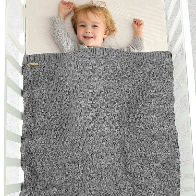 Solid colour acrylic infant blanket with raised lines, shown in a light green colour.