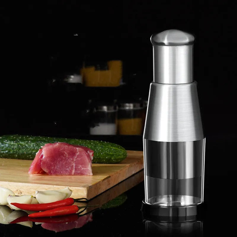 Black manual garlic crusher and onion chopper with stainless steel blades on kitchen counter