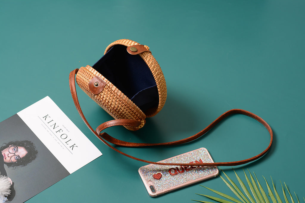 A collection of hand-woven tropical straw purses in various shapes, sizes, and designs, perfect for Kiwi summer style.