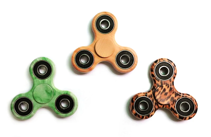 A premium designer spinner in various colors, designed to provide stress relief and improve focus for Kiwis