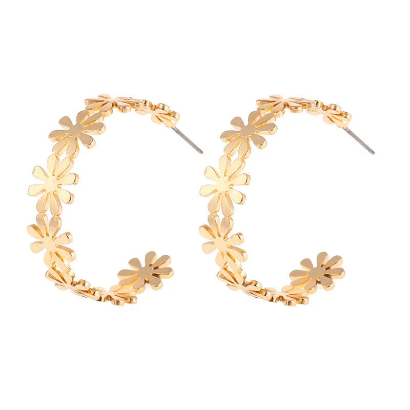 A pair of golden geometric c-shaped flower drop earrings, a timeless New Zealand fashion accessory