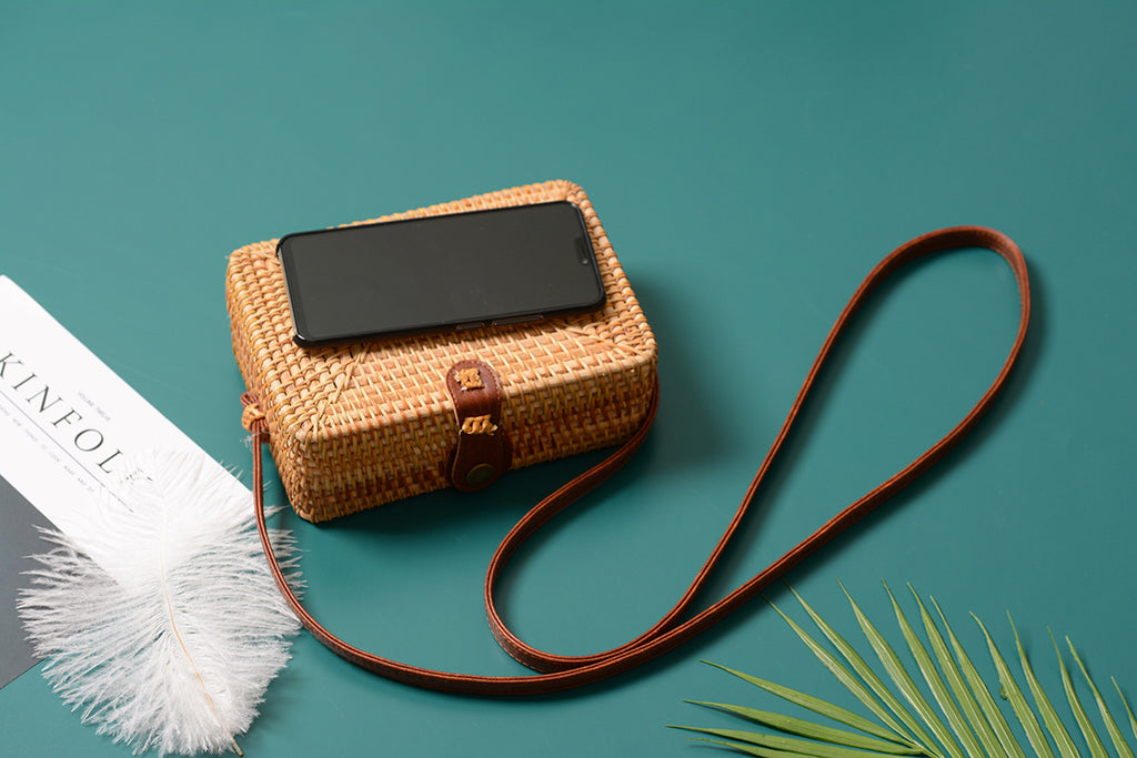 A collection of hand-woven tropical straw purses in various shapes, sizes, and designs, perfect for Kiwi summer style.