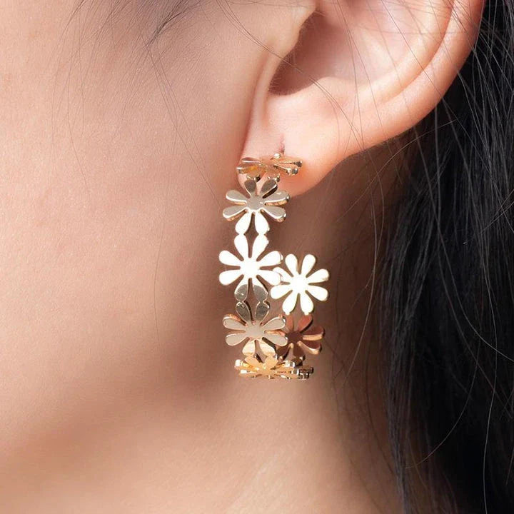 A pair of golden geometric c-shaped flower drop earrings, a timeless New Zealand fashion accessory